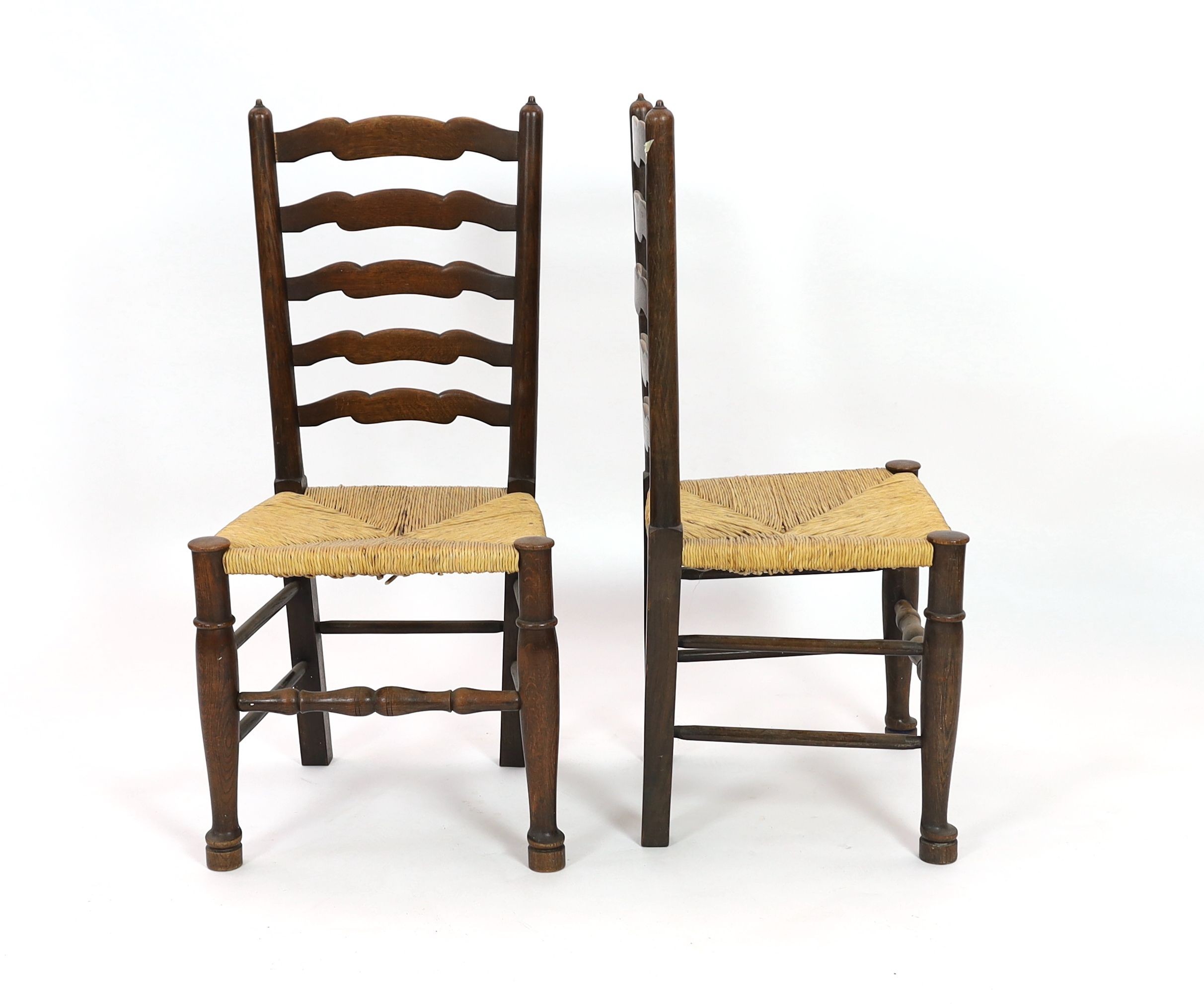 A pair of 18th century style rush seat oak ladderback dining chairs